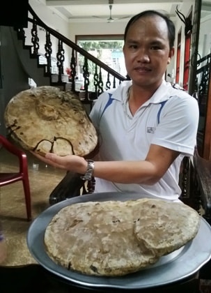 Anh Trần Văn Thọ bên 2 cây nấm khổng lồ được anh cho là nấm linh chi.