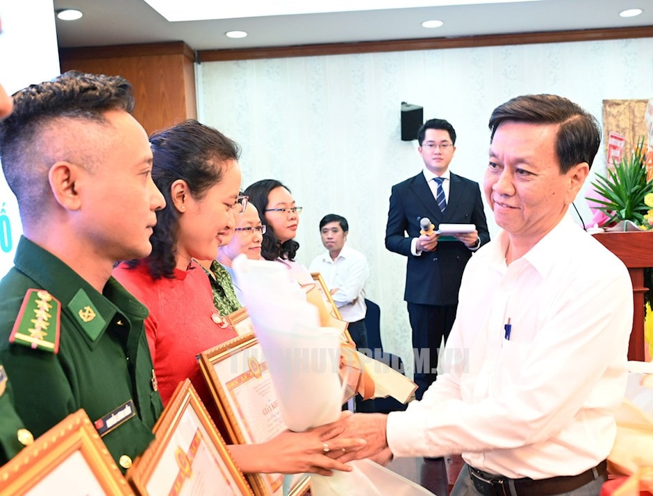 Phó trưởng Ban Tuyên giáo Thành ủy TP.HCM Nguyễn Thọ Truyền tặng hoa cho các cá nhân. (ảnh: S. Hải)